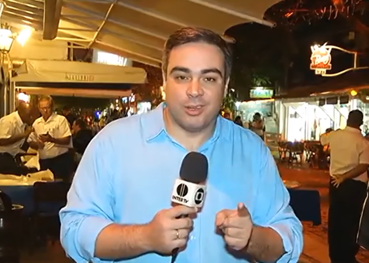 Flavio Flarys com o microfone da Inter TV durante uma reportagem